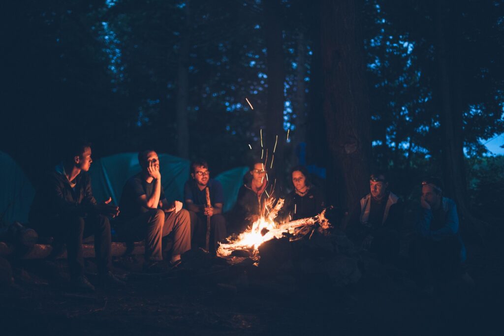 Groupe de personnes autour d'un feu en pleine nature